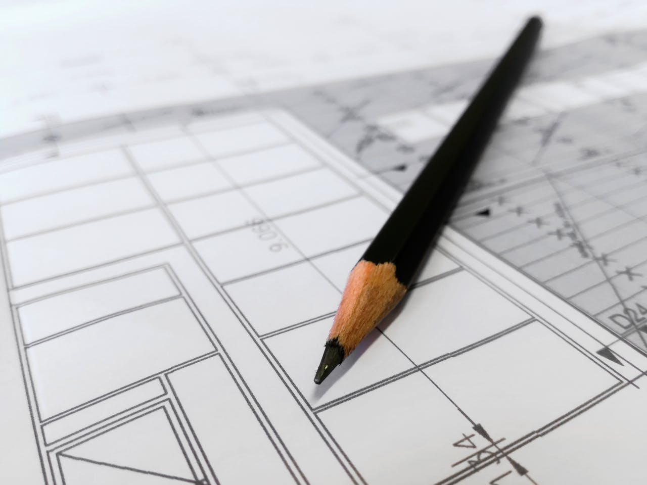 services-02 Detailed image of a black pencil resting on architectural blueprints, ideal for design and planning themes.