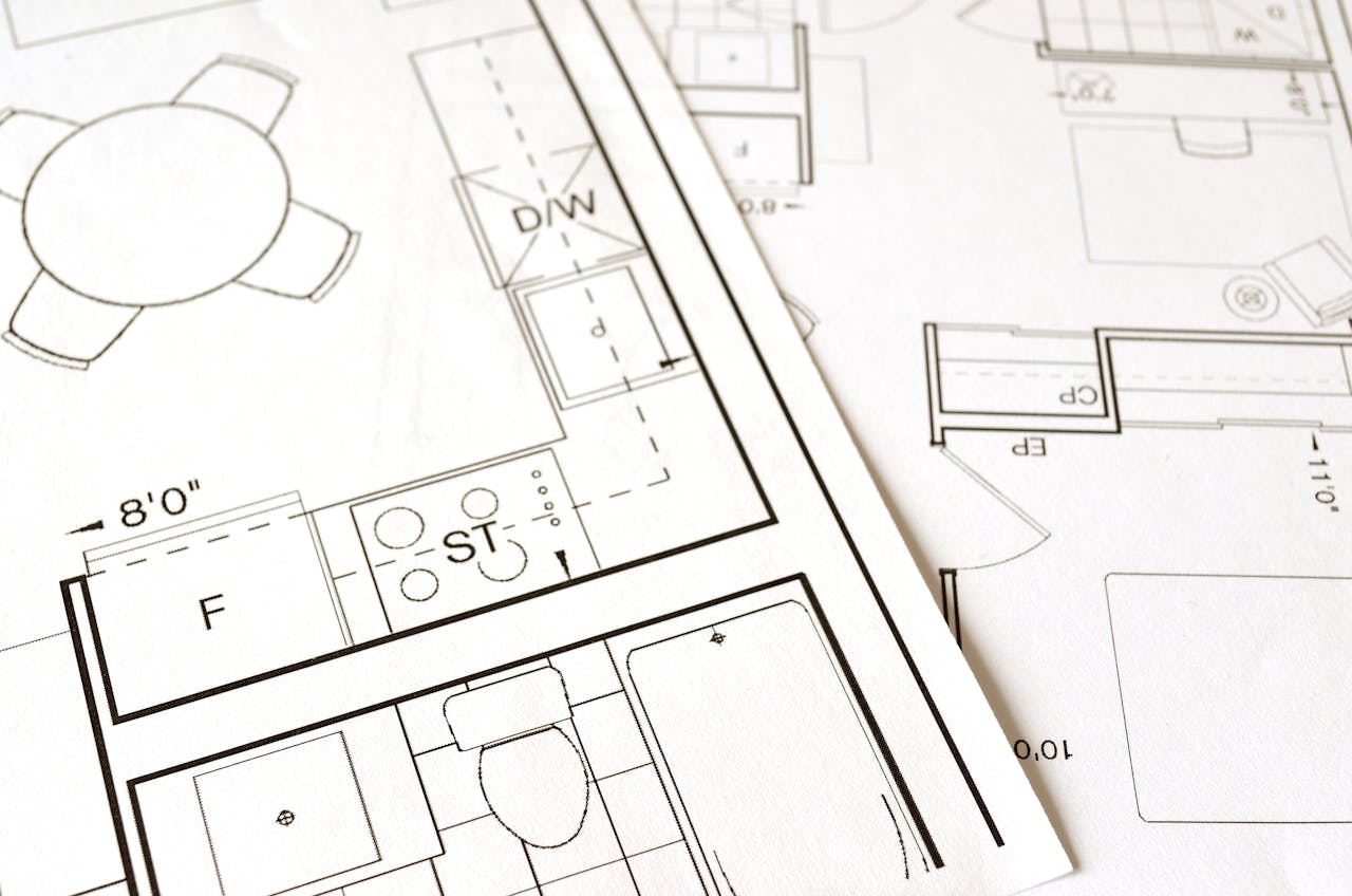 services-04 Close-up view of an architectural floor plan on paper showcasing detailed room layouts and measurements.